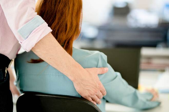 Man holding woman on the sides at work - Sexual Harassement